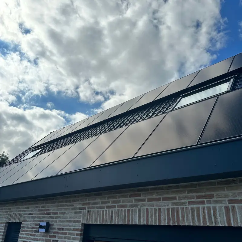 La nouvelle toiture avec panneaux solaires et fenêtres de toit, au-dessus de la façade en briques.